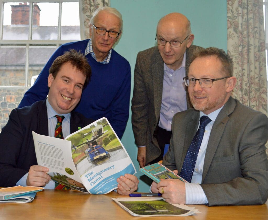 Craig Williams, MP, and Russell George, MS, with Montgomery Canal Partnership’s chair John Dodwell (standing right) and Montgomery Waterway Restoration Trust chairman Michael Limbrey (standing left).