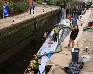 Pipework being passed down into Lock 92 on the Rochdale Canal to pump out water from the sunken narrowboat