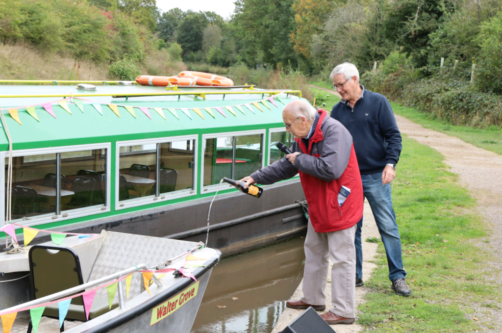 Christening the Walter Grove are, from left: Ian Hair, cousin of benefactor Peter Grove, who named the boat after his grandfather Walter Grove and John Reynolds, Wey & Arun Canal Trust boat director. PHOTO: JULIAN MORGAN