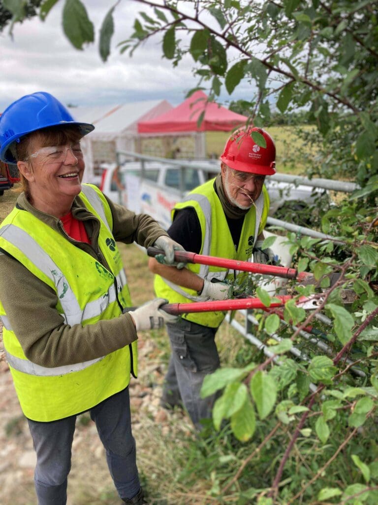 Volunteers cutting back vegetation