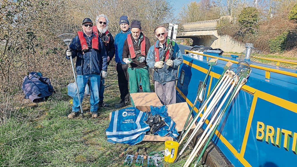 Beside work boat Python with the new tools and protective gear are Dan Hazard of the Canal & River Trust, centre, with Chesterfield Canal Trust volunteers Chris Happer, Dave Warsop, Andy Ledbetter and Keith Watkins.  PHOTO: CHESTERFIELD CANAL TRUST