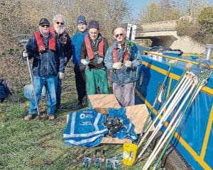 Beside work boat Python with the new tools and protective gear are Dan Hazard of the Canal & River Trust, centre, with Chesterfield Canal Trust volunteers Chris Happer, Dave Warsop, Andy Ledbetter and Keith Watkins. PHOTO: CHESTERFIELD CANAL TRUST