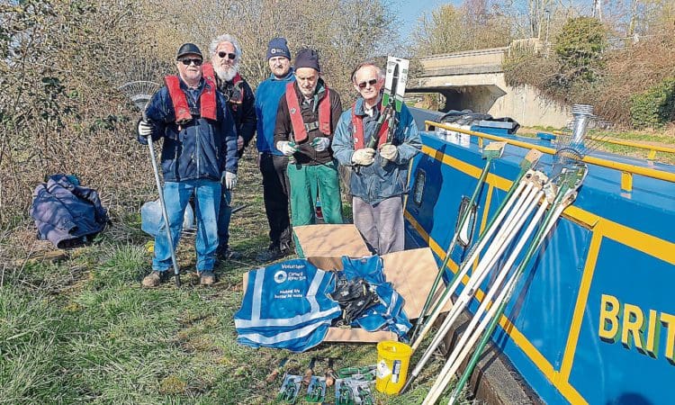 Beside work boat Python with the new tools and protective gear are Dan Hazard of the Canal & River Trust, centre, with Chesterfield Canal Trust volunteers Chris Happer, Dave Warsop, Andy Ledbetter and Keith Watkins. PHOTO: CHESTERFIELD CANAL TRUST