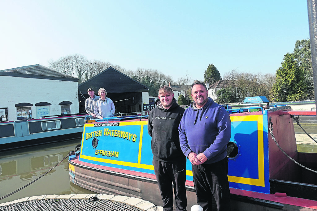 Father and son narrowboat painters Dave and Aaron Bishop with proud owners Keith and Jill Astley astern on the repainted Effingham at Braunston Marina. PHOTO: TIM COGHLAN