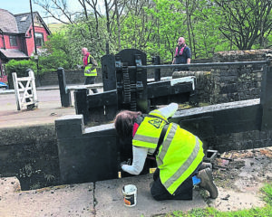 Painting the gates at Wade Lock on the Huddersfield Narrow Canal. PHOTOS: UCAN