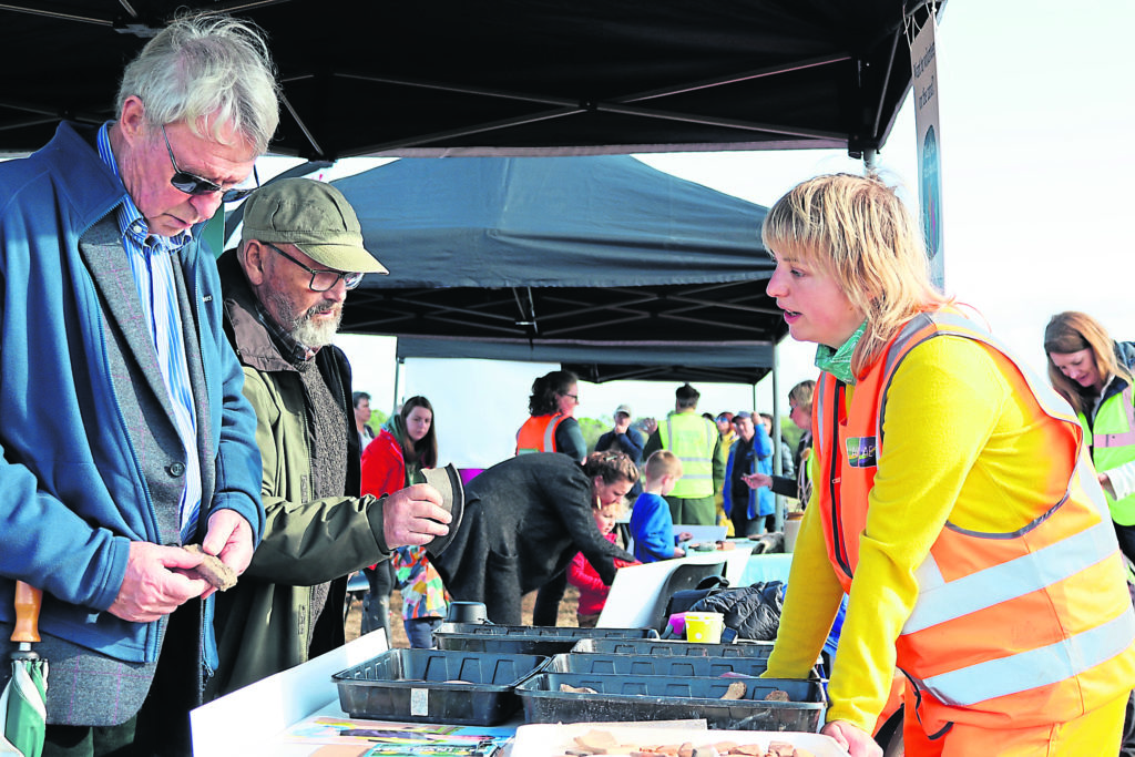 A member of the Archaeology England team talks to visitors about the finds.